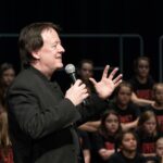 James Wright speaking to “Listen Up” audience and choristers (May 2017)